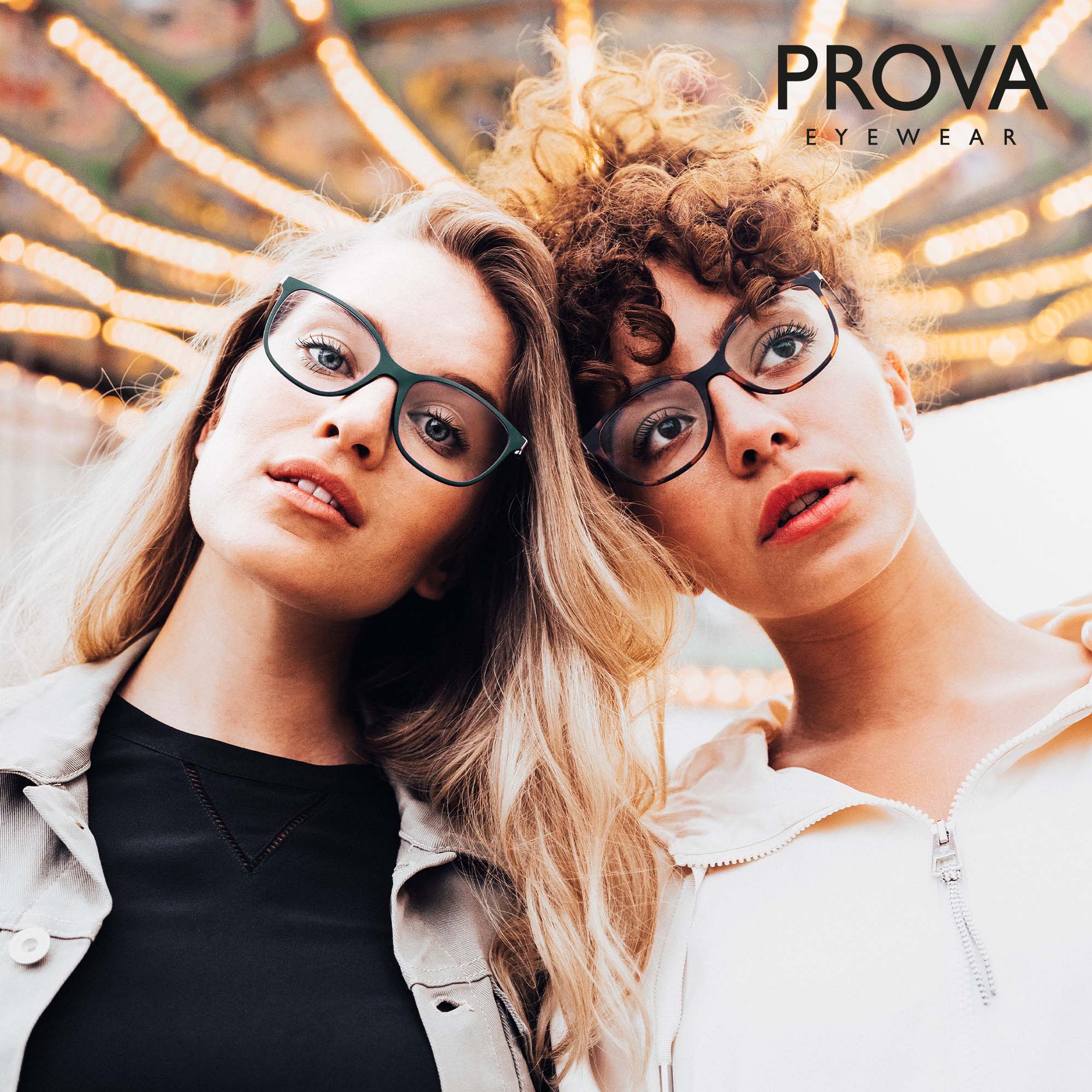 Zwei Frauen stehen zusammen vor einem Karussell und tragen Brillen von PROVA Eyewear